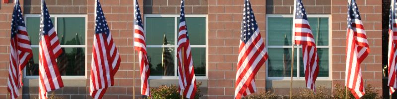American flags lining sidewalk in front of school building 